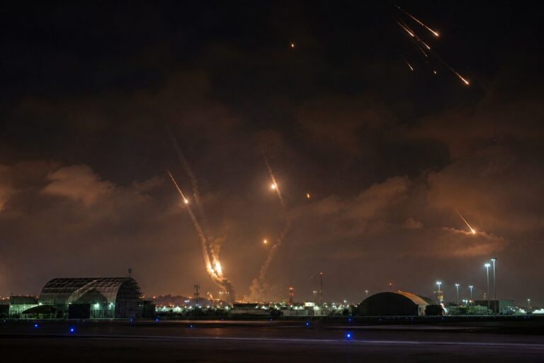 Missile trails and interceptions lighting the night sky over a military base