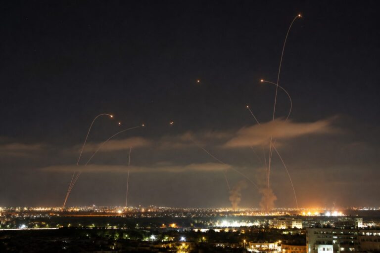 Interceptor trails arcing over a lit city skyline at night