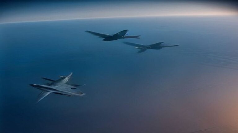 Three military jets flying over the sea in a high-altitude view