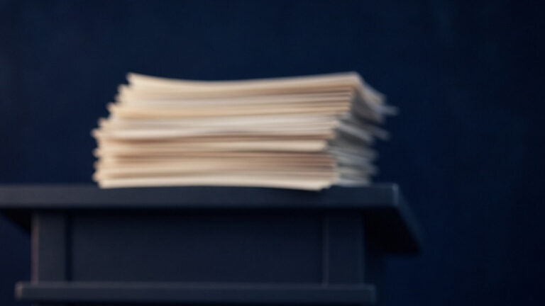 Transcript pages and an open notebook with a pen on a dark navy ground: Ed Miliband, UNSC Address